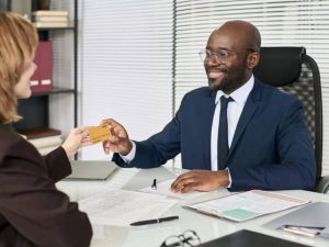 Article Banques professionnelles US - Un conseiller bancaire tend une carte bancaire à une cliente
