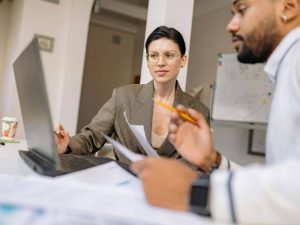 Article CIP-KYC - Deux associés, homme et femme, qui analysent des informations affichées à l’écran d'un ordinateur