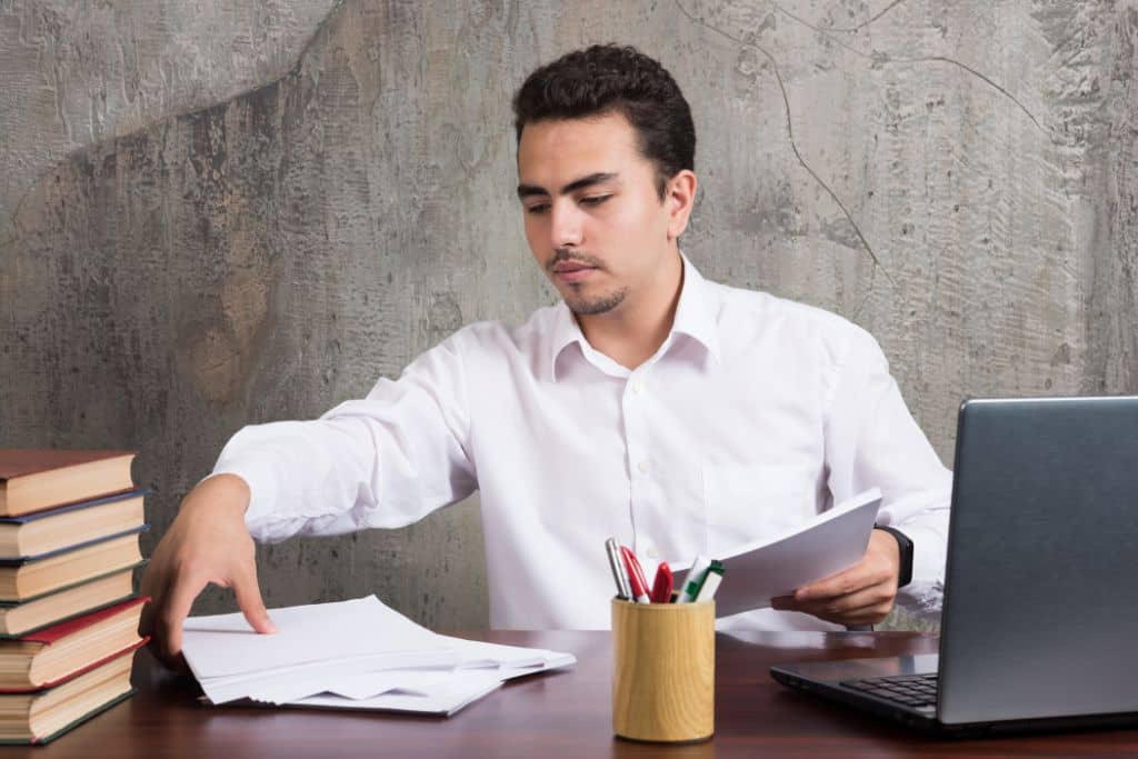 Article créer une llc en Oklahoma - Un représentant légal qui arrange des documents papier sur son bureau