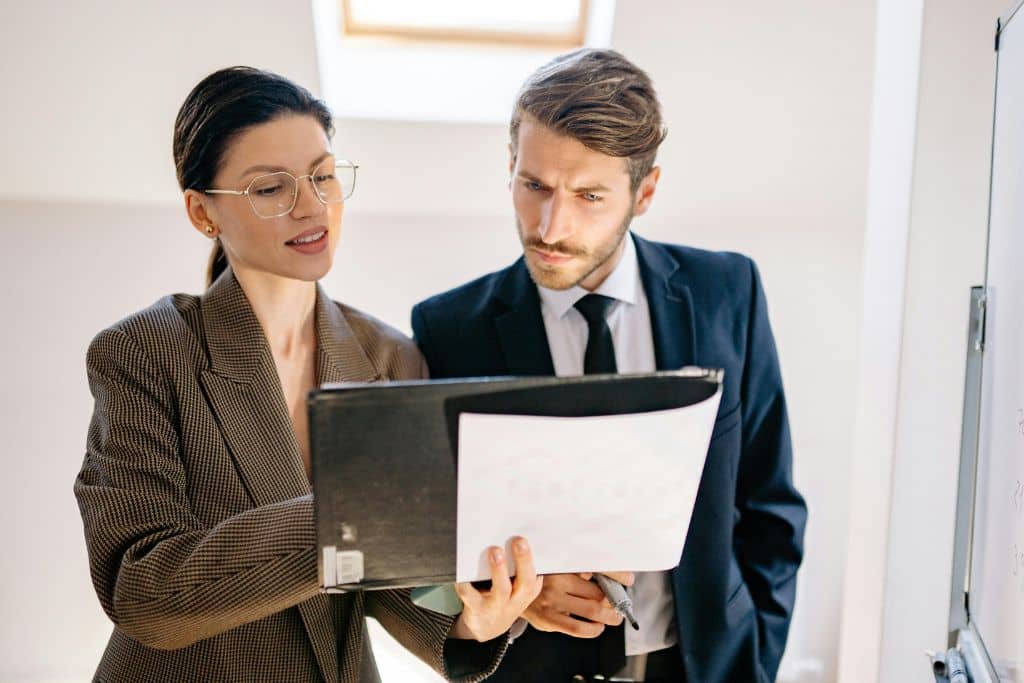 Article créer une LLC en Caroline du Sud - Une professionnelle en création d'entreprise et son collègue qui regarde un document sur les LLC