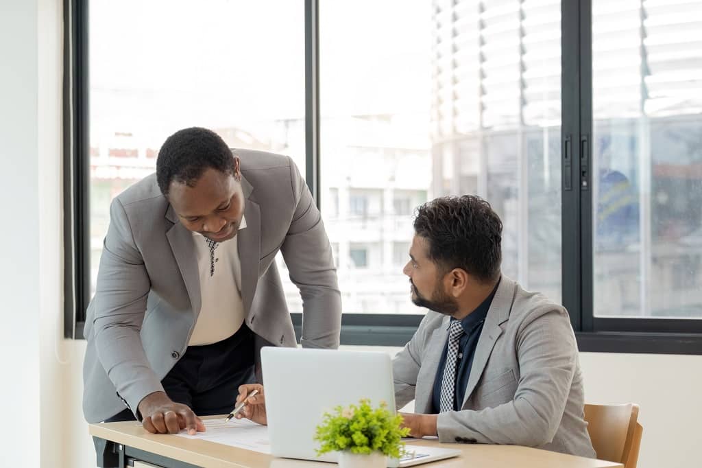 Article créer une LLC au Colorado - Un représentant légal aux USA et son collègue qui étudie un dossier