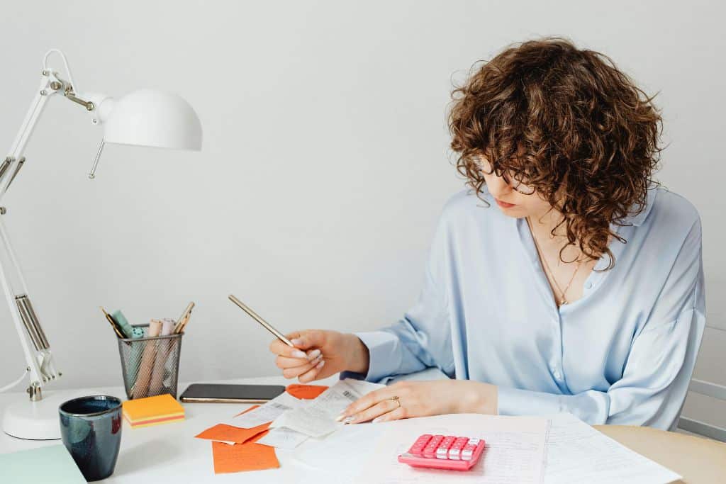 Article Créer une LLC au Dakota du Sud - Une jeune entrepreneure calculant le budget de création de son entreprise