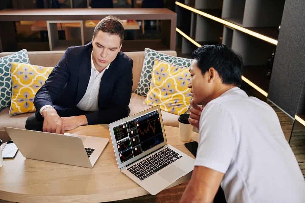 Article creer une LLC à Hawaii - Deux associés analysant des données sur ordinateur