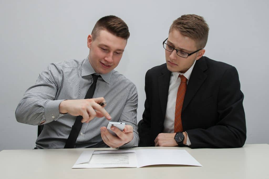 Article créer une llc dans le Mississippi - Deux collègues regarde des infos sur un smartphone