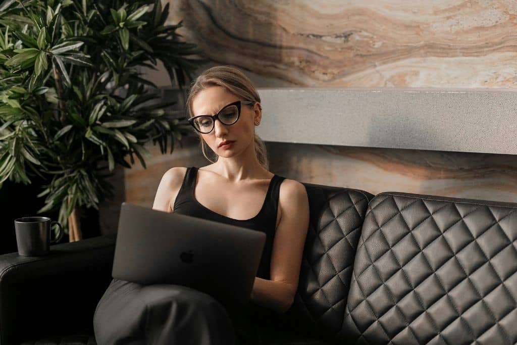 Article créer une llc dans le Missouri - Une entrepreneure assise sur un canapé avec son ordinateur