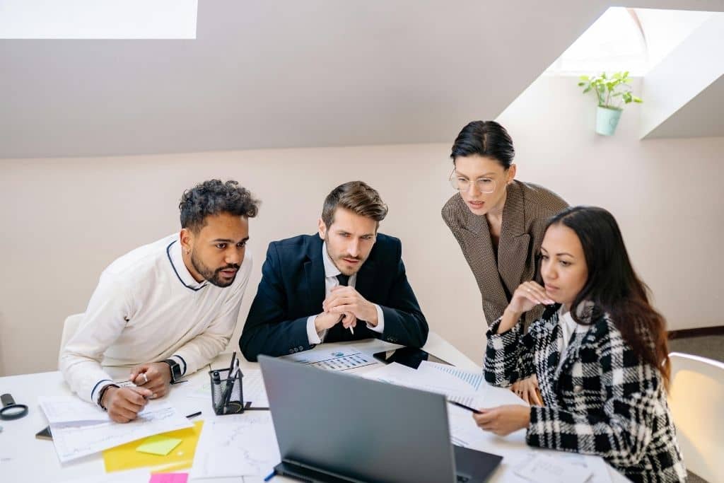 Article créer une llc dans le Nebraska - Des associés qui se concertent en regardant des informations sur un ordinateur