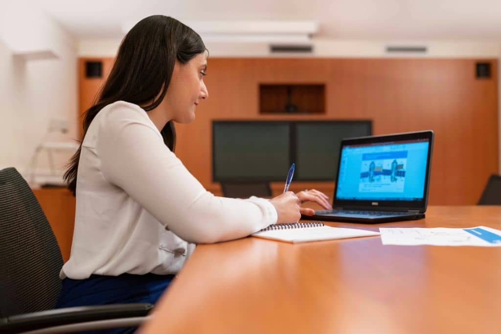 Article créer une llc dans le New Hampshire - Une entrepreneure qui prend note sur son carnet devant son ordinateur