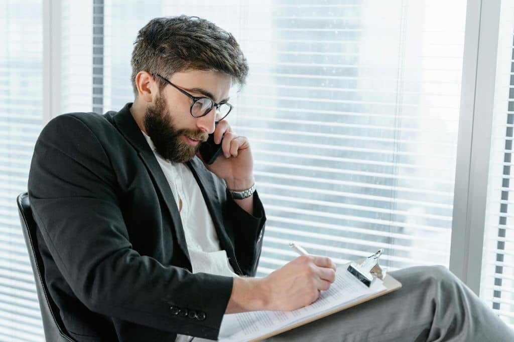 Article créer une llc dans le New Jersey - Un consultant étudie des dossiers et qui est au téléphone