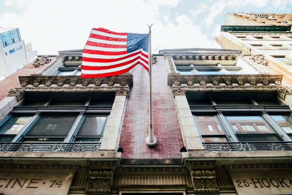 Article créer une llc à New York - Un drapeau américain sur la façade d'un bâtiment