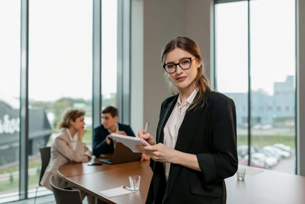 Article créer une llc dans le Nouveau-Mexique - Une registered agent debout qui prend note sur un carnet