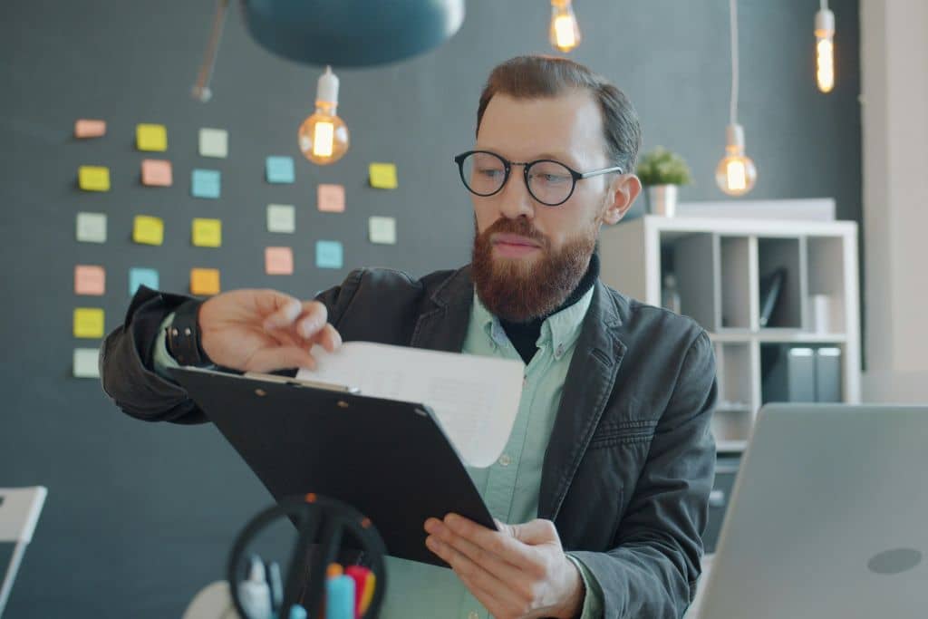 Article créer une llc dans le Nouveau-mexique - Un entrepreneur qui vérifie un dossier papier sur son bureau