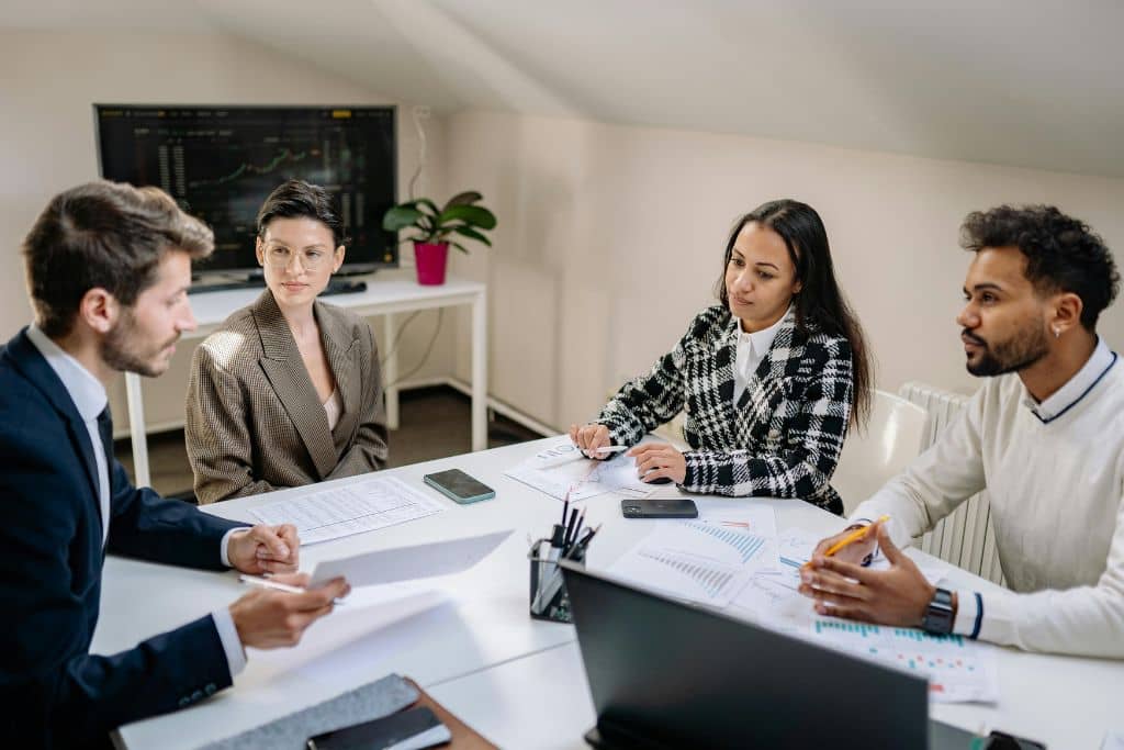 Article créer une llc dans le Nouveau-mexique - Une équipe de quatre personnes se concertant sur la dissolution d'une entreprise