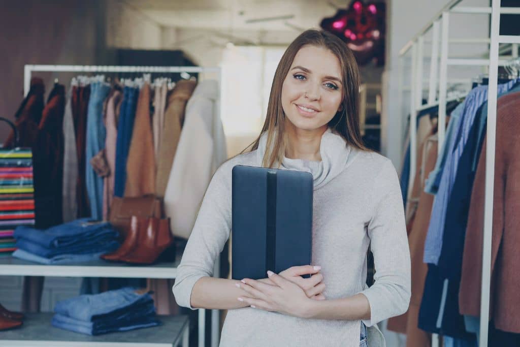 Article créer une llc dans l'Ohio - Une entrepreneure se tenant dans sa boutique et tenant une tablette en main