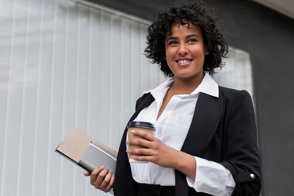 Article créer une llc en Virginie-occidentale - Une représentante légale qui tient un dossier en main droite et un café dans l'autre main