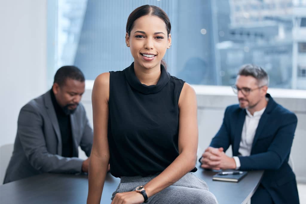 Article États américains à faible imposition pour entrepreneurs non résidents - Une femme entrepreneuse et deux collègues en arrière plan