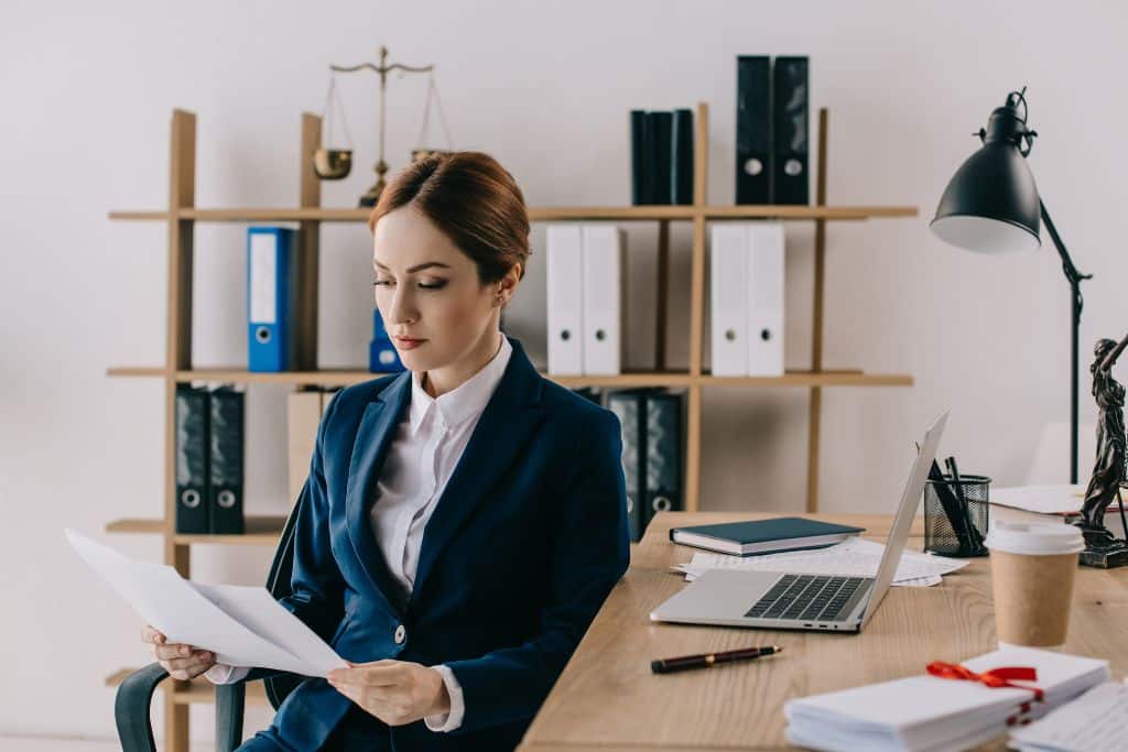 Article formulaires fiscaux pour non-résidents - Une entrepreneure assise à son bureau concentrée sur l’analyse de plusieurs documents fiscaux