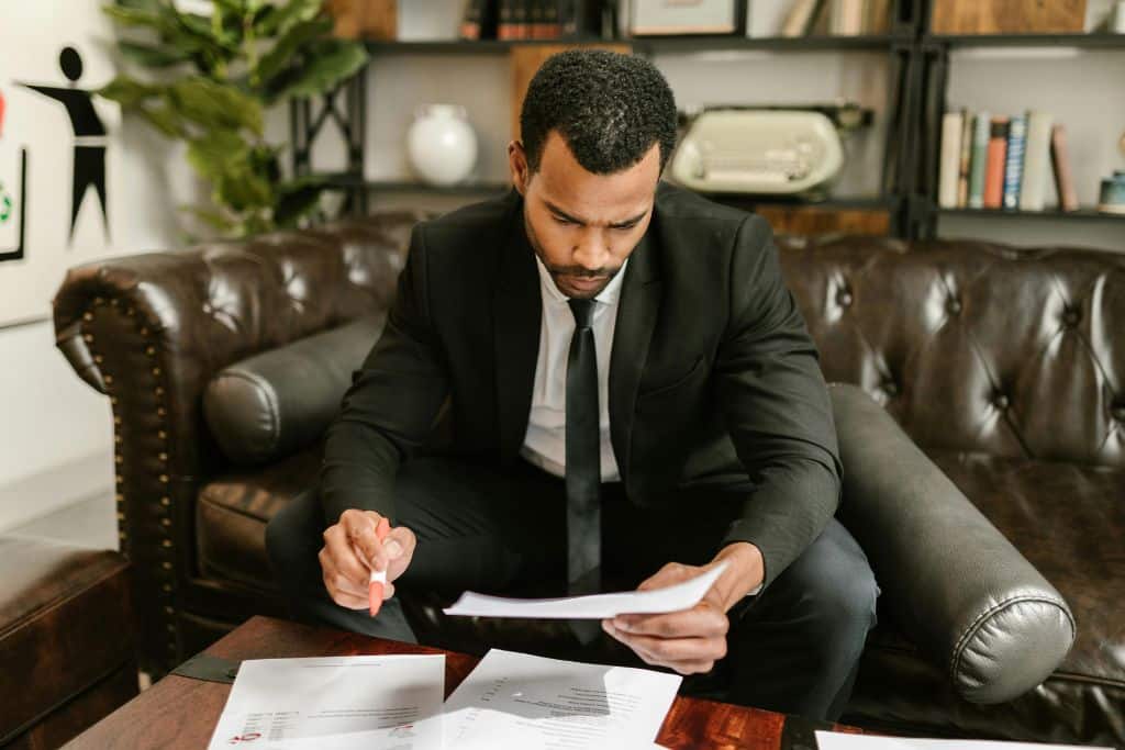 Article formulaires fiscaux pour non-résidents - Un entrepreneur assis sur un sofa examinant attentivement des documents