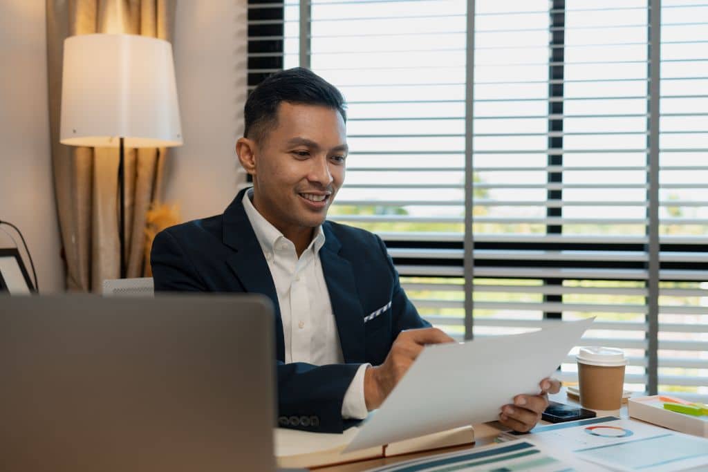 Article grandes banques US et réseaux - Un entrepreneur attentif relit des documents bancaires sur son bureau