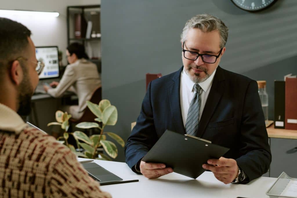 Article grandes banques US et réseaux - Un agent bancaire examine les dossiers d’un client entrepreneur