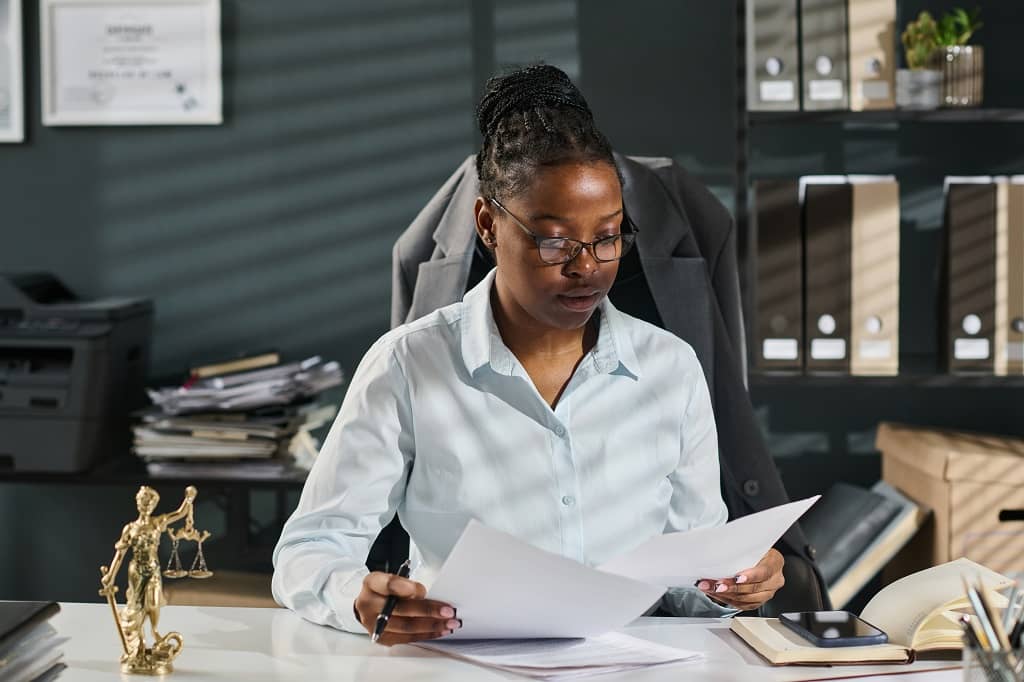 Une spécialiste en création et dissolution d’entreprise examine les dossiers relatifs à la fermeture d’une LLC.