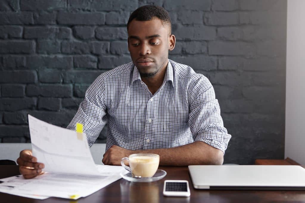 LLC vs C-Corp du Delaware - Un entrepreneur qui examine des documents sur son bureau