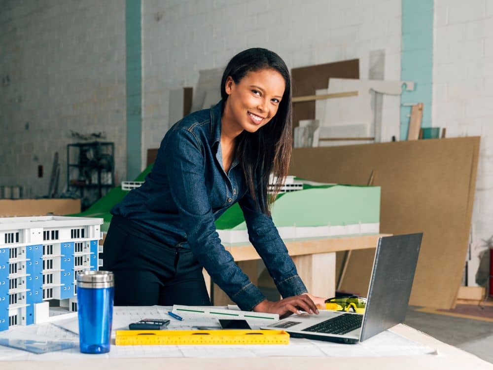 Article LLC vs GmbH allemande - Une entrepreneure souriante qui travaille sur son ordinateur