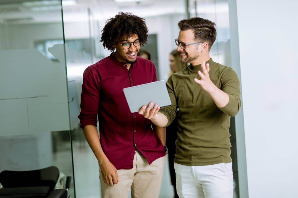 Article LLC vs Holding Company du Wyoming - Deux collègues associés discutent avec enthousiasme sur des données dans une tablette