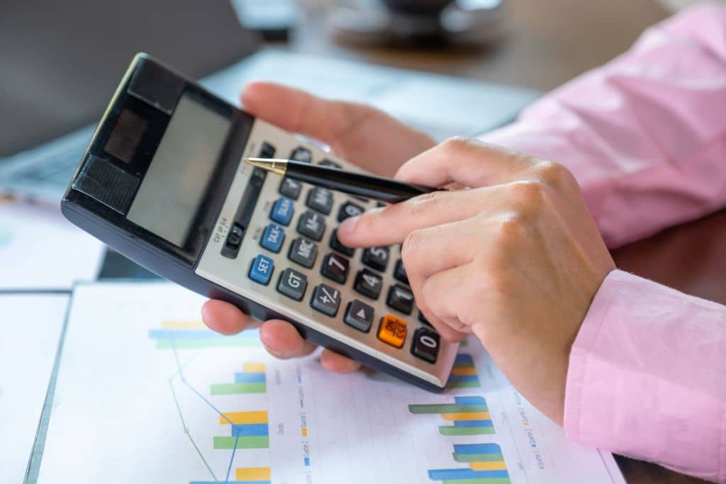 Article LLC vs Holding Company du Wyoming - Une main effectue un calcul fiscal sur une calculatrice