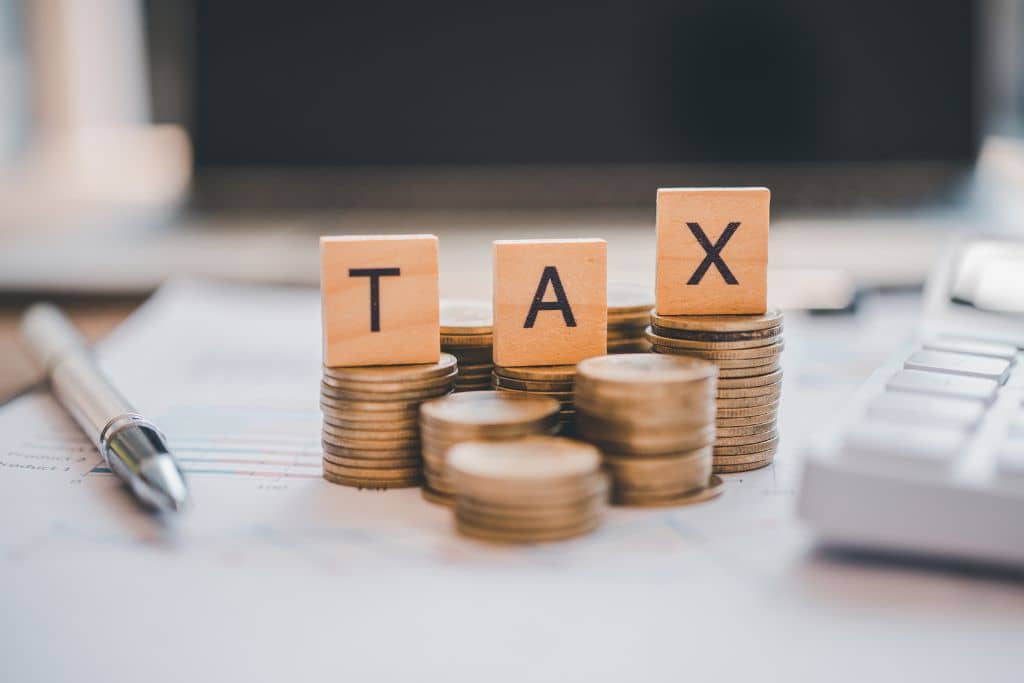 Article LLC vs IBC Seychelles - Le mot TAX au-dessus de plusieurs piles de pièces de monnaies