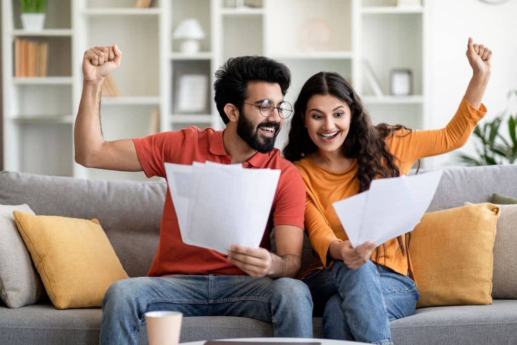 Article LLC vs Limited Company de Chypre - Un couple d’entrepreneurs célèbre une réussite professionnelle, dossiers en main