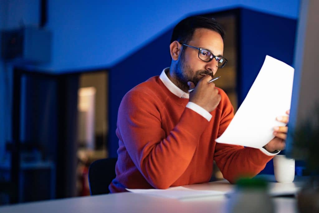 Article LLC vs Limited Company d’Irlande - Un entrepreneur examine un document sur son entreprise avec attention