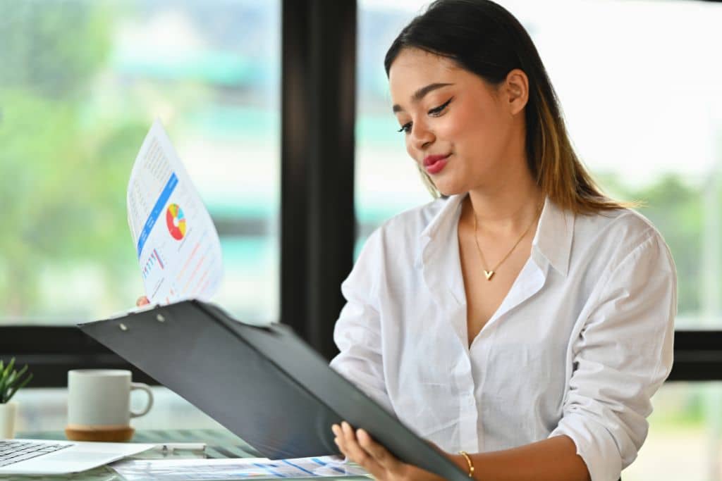 Article LLC vs Limited Company d’Irlande - Une entrepreneure qui examine des rapports et données sur son entreprise