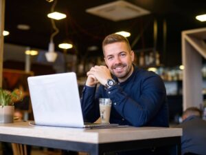 Article LLC vs SLU Espagne - Un entrepreneur souriant travaillant dans un café