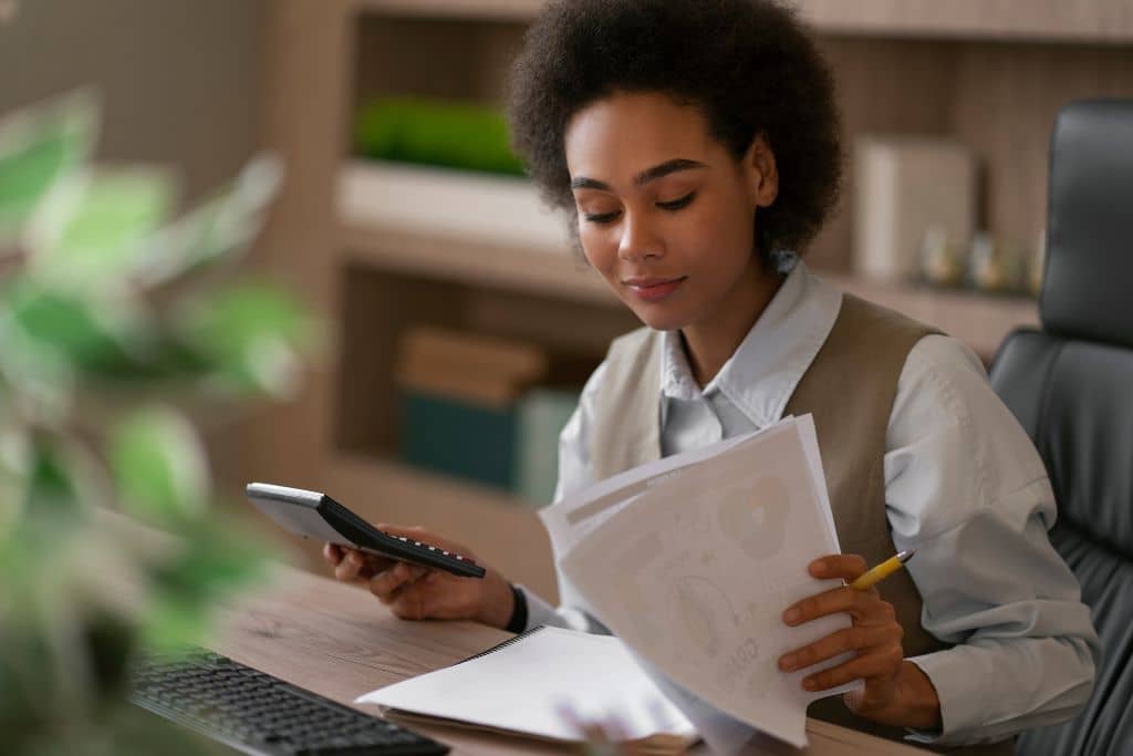 Article LLC vs SLU Espagne - Une entrepreneure analyse des documents et effectue des calculs concernant la fiscalité de son entreprise