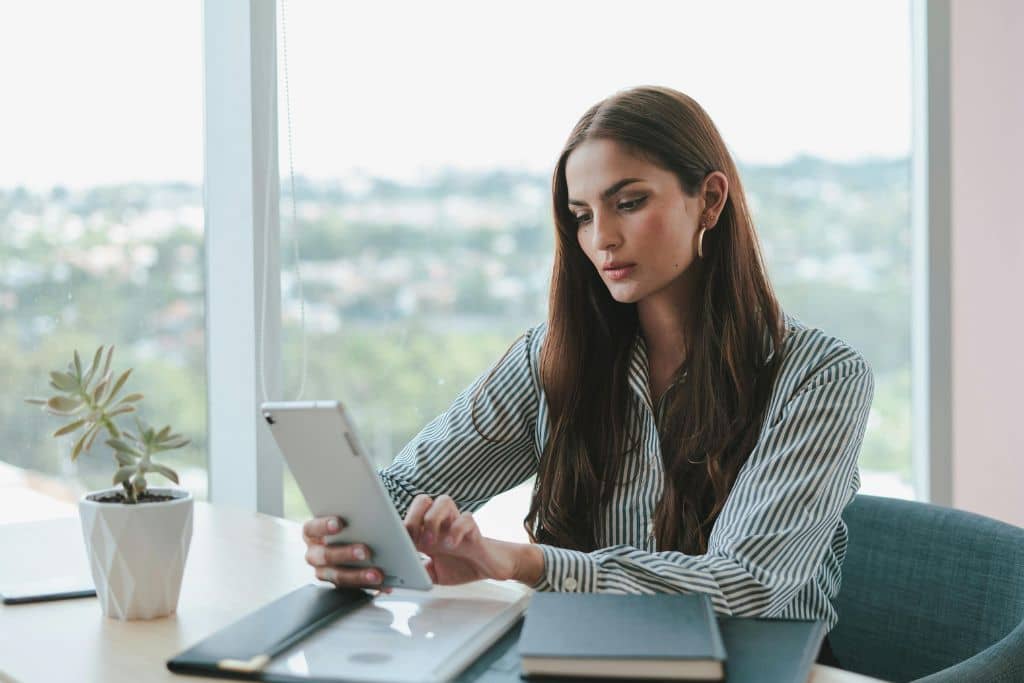 Article LLC vs SLU Espagne - Une femme entrepreneure consulte sa tablette