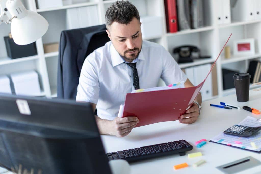 Article LLC vs SOPARFI Luxembourg - Un homme entrepreneur qui analyse des dossiers sur la création d'entreprise