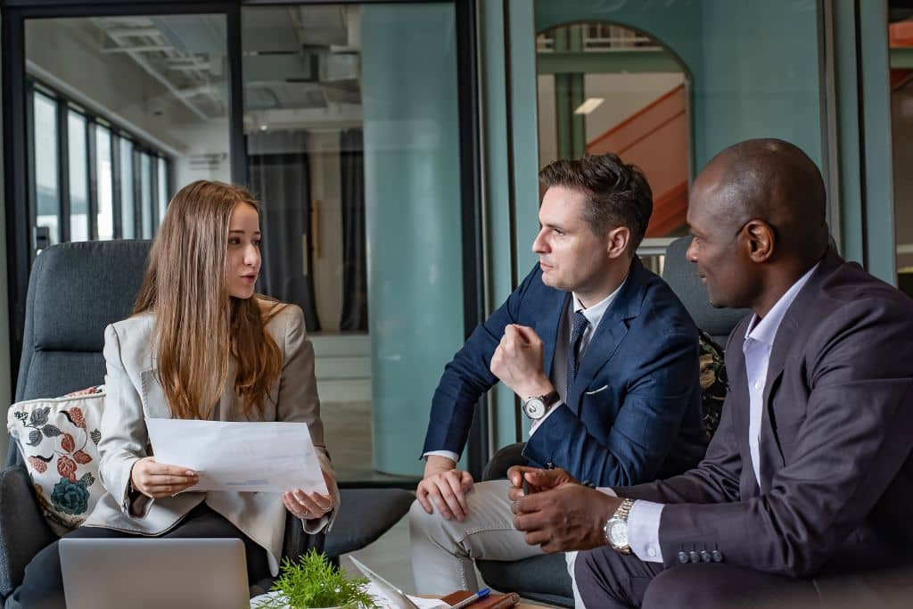 Article LLC vs SOPARFI Luxembourg - Une femme expose un document professionnel à ses associés