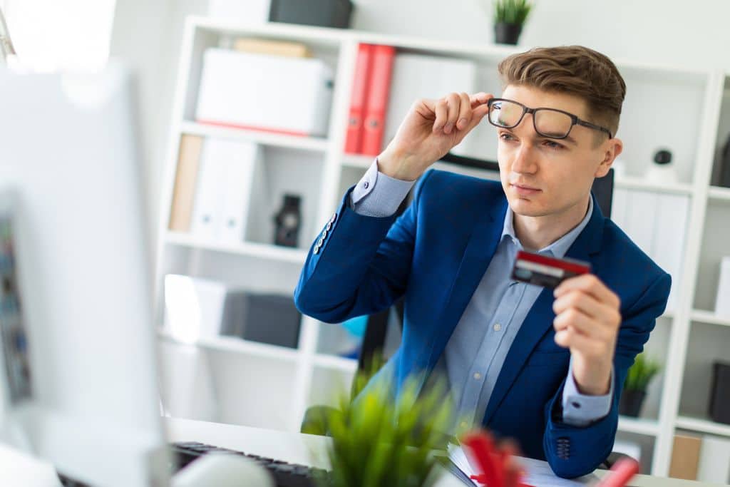 Article ouvrir un compte bancaire us - Un homme consulte son écran pour voir comment effectuer une transaction en ligne avec sa carte bancaire