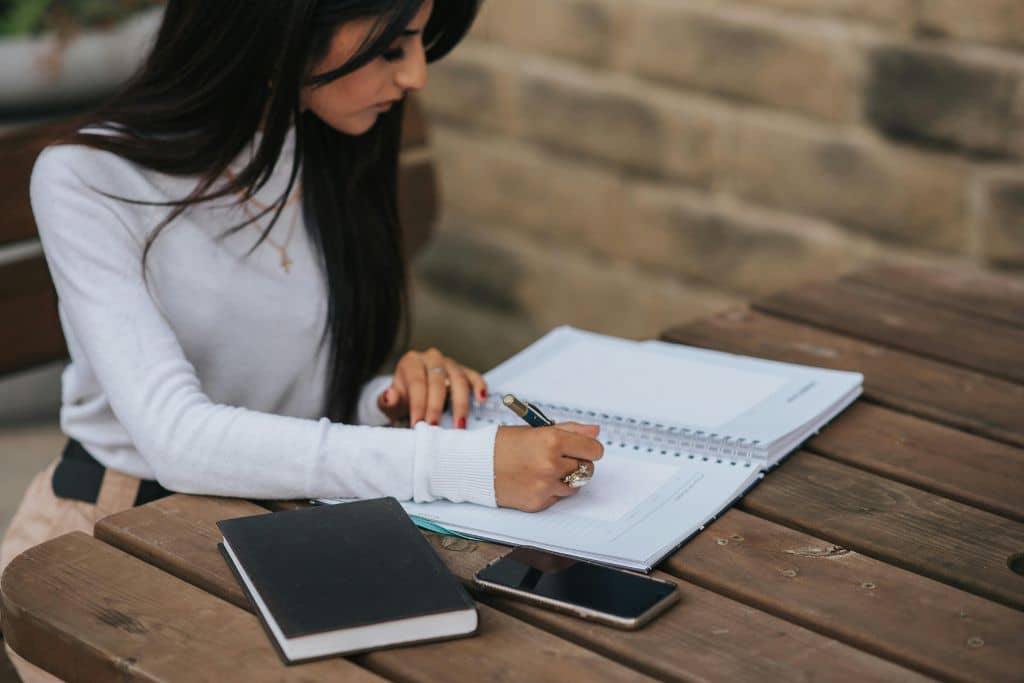 Article pièces à fournir aux banques US - Une jeune entrepreneure consulte attentivement une checklist