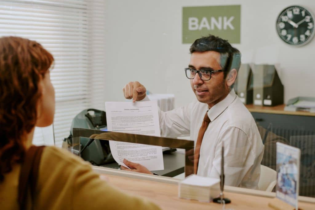 Article régulateurs et assurance des dépôts - Un conseiller bancaire présente et détaille un dossier à une cliente