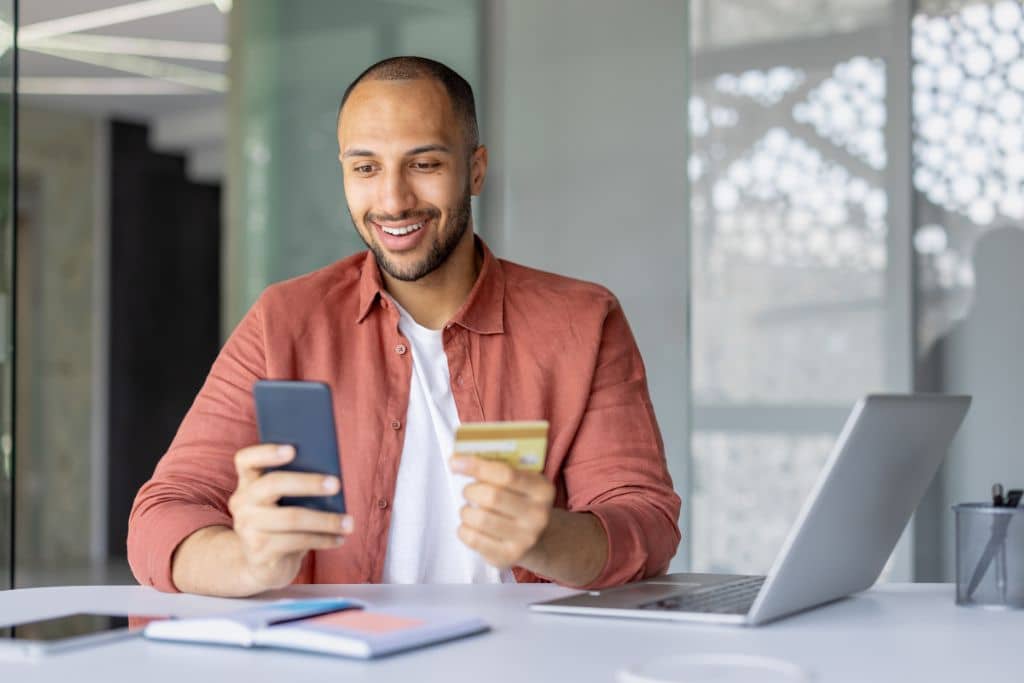 Article régulateurs et assurance des dépôts - Un entrepreneur utilise sa carte de crédit pour une transaction numérique