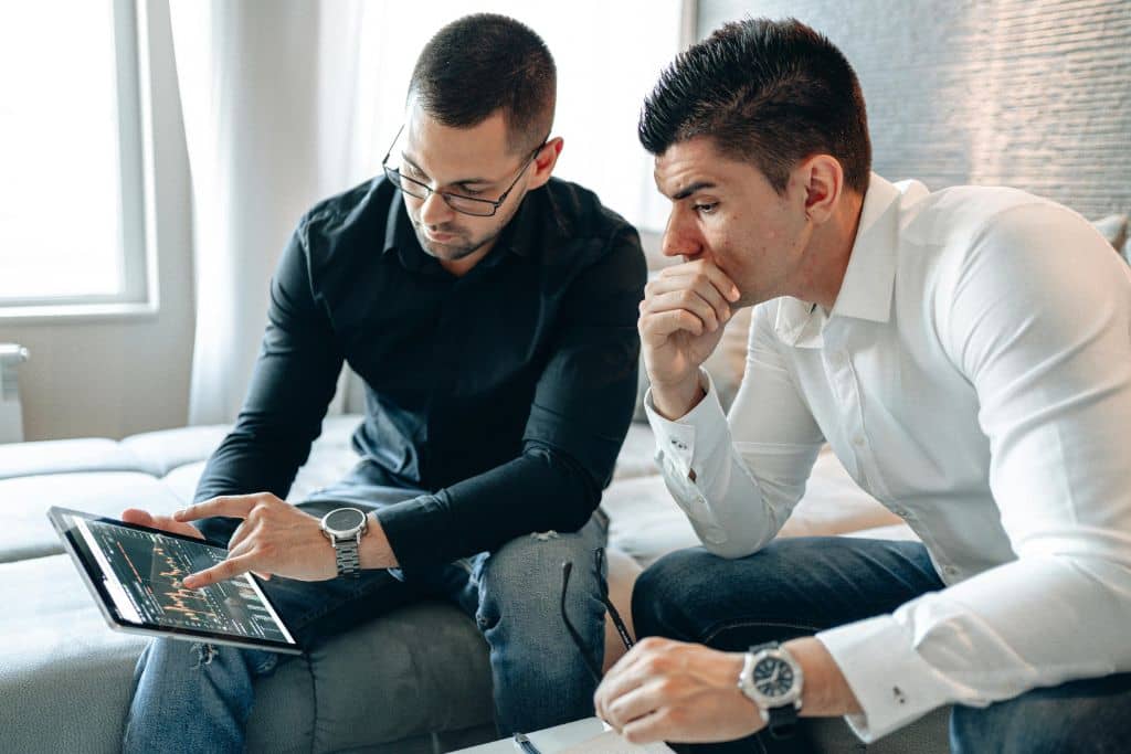 Article sécurité, fraudes et limites de risque - Deux associés examinent des graphiques sur l’évolution de la trésorerie de leur entreprise