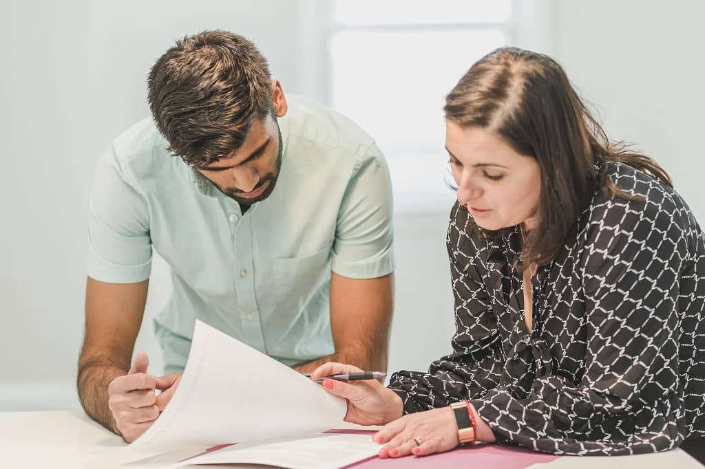 Article TIN - Un homme et une femme non-résidents en train de remplir des formulaires relatifs au TIN