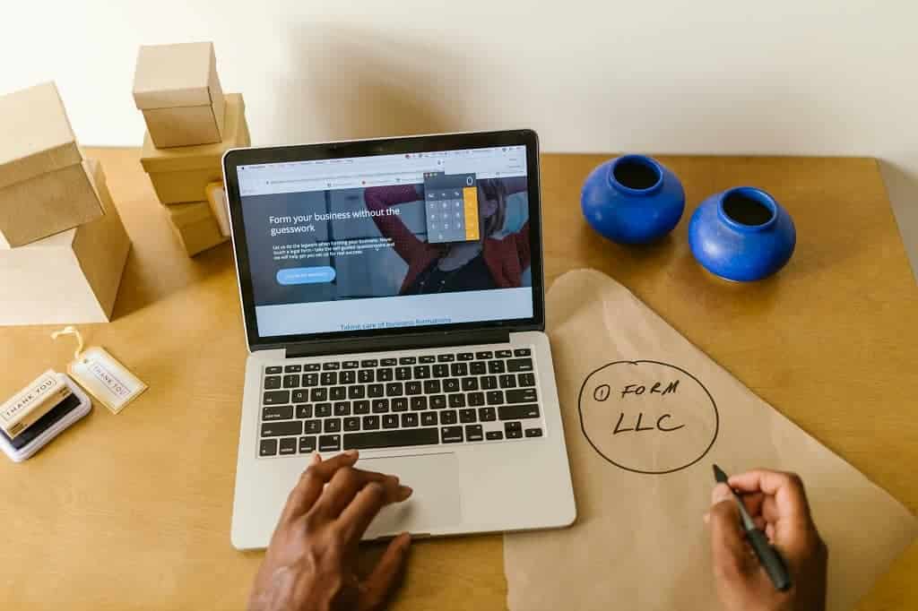 Article TIN - Un ordinateur sur bureau et l'inscription Form LLC sur papier