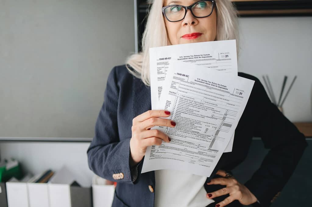 Article TIN - Une femme tenant plusieurs formulaires en main