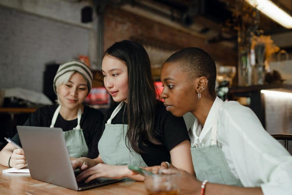 Trois femmes entrepreneures font une demande de visa e2 créer leur entreprise aux États-Unis.